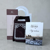 Hajj cadeau giftbag met drinkfles, draagbaar gebedskleed en wenskaart als islamitisch cadeau