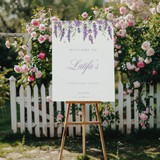 Gepersonaliseerd welkomstbord voor afstudeerfeest met paarse bloemen
